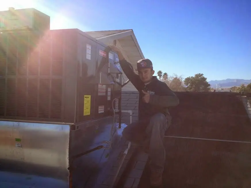 HVAC technician performing AC Tune-Up on a rooftop unit in Parkville